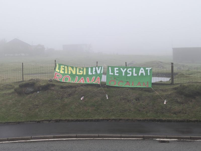 Tveir bannarir við eina rundkoyring. Á bannarunum stendur: 'Leingi livi rojava' og 'Leyslat Öcalan'
